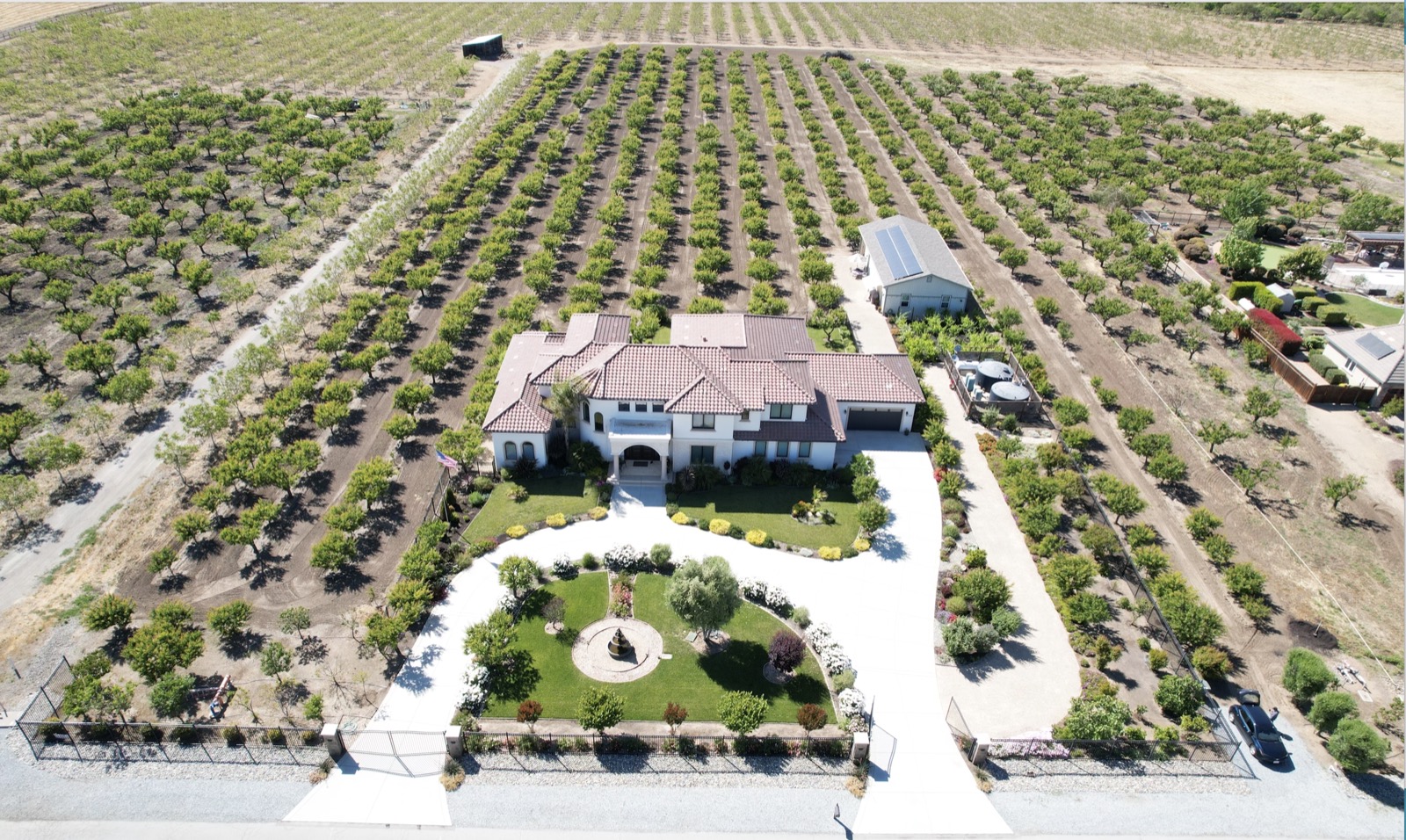 Aerial view of the farmhouse, barn, gazebo, and orchard rows